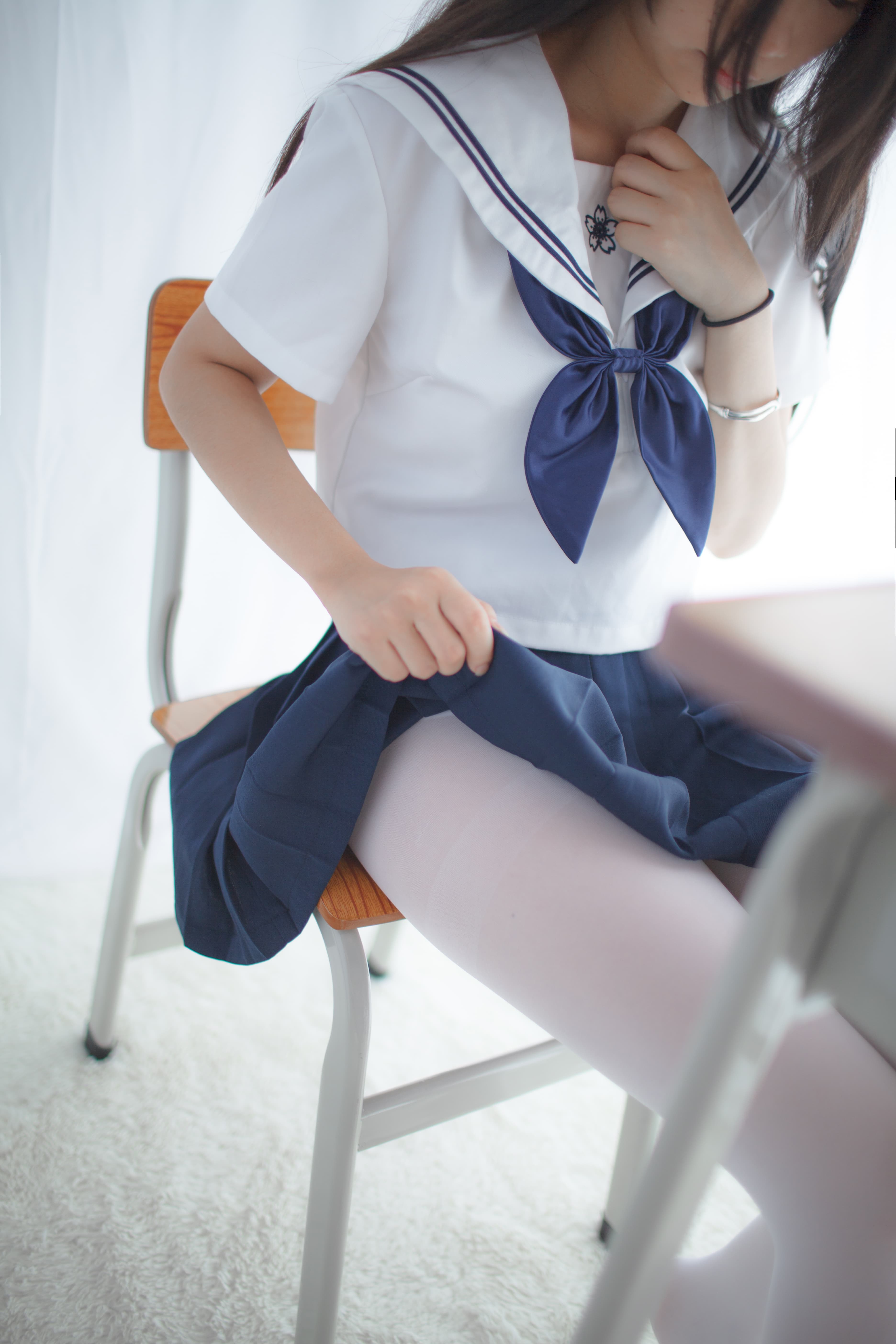 Sunlit classroom corner with adult model adjusting stockings and revealing ankle above polished floor